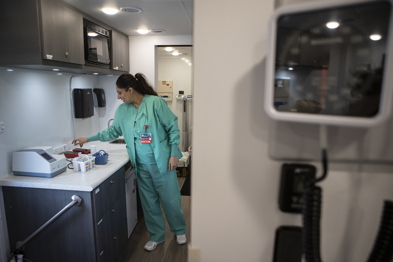 A healthcare worker in teal scrubs prepares supplies in a clinic as the uninsured rate rises. — uninsured rate rising