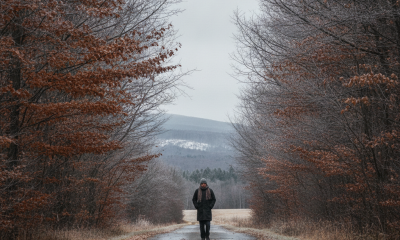 A person walking down a deserted road lined with trees, showcasing autumn foliage in — Bennington County weather forecast