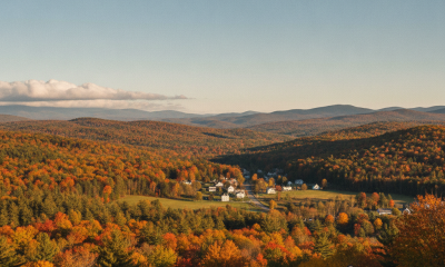 Bennington County weather forecast: three people overlook colorful autumn hills beneath a clear sky.