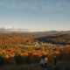 Bennington County weather forecast: three people overlook colorful autumn hills beneath a clear sky.