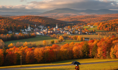 Bennington weather forecast over a sunlit autumn valley, with colorful hills, a village, and a person walking beneath a da…