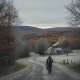 A person walking along a winding road in Bennington County, surrounded by autumn foli — Bennington County weather forecast