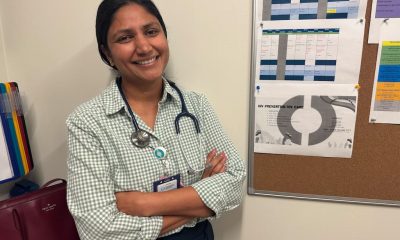A smiling female doctor with a stethoscope stands with arms crossed in front of a bul — foreign doctors physician shortage