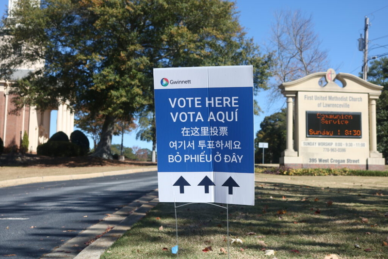 DHS voter investigations naturalized citizens story context: multilingual Gwinnett “Vote Here” sign outside a church p…