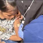 A young child receiving a vaccination in a healthcare setting, highlighting the New York measles emergency response.