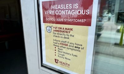 A sign warning about the contagious nature of measles, instructing people to wear masks and check — US measles cases 2025