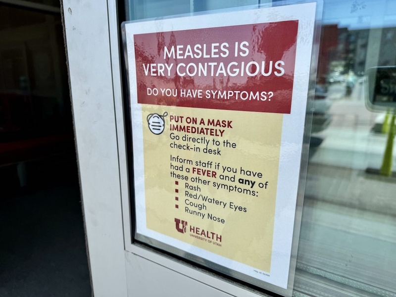 A sign warning about the contagious nature of measles, instructing people to wear masks and check — US measles cases 2025