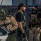 Law enforcement officers in tactical gear at a scene, highlighting — federal funding local police immigration enforcement