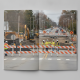 Construction workers in safety vests manage roadwork with heavy machinery and traffic ba — Bennington VT Road Construction