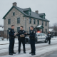 Officers confer beside a police cruiser outside a stone building during the Shaftsbury Barracks child cruelty investigation.