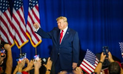 Former President Trump raises his fist in front of a crowd, with American flags in t — Trump midterm election interference