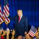 Former President Trump raises his fist in front of a crowd, with American flags in t — Trump midterm election interference