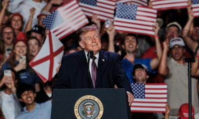 Donald Trump speaking at a rally with supporters holding American flags in the background, highligh — Trump mail-in voting