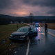 Vermont State Police Shaftsbury Barracks officers investigate a damaged sedan on a wet rural road at dusk.