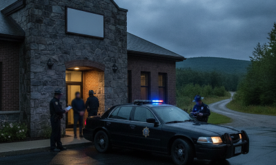 Vermont State Police Shaftsbury Barracks building with officers and a patrol car under a cloudy evening sky